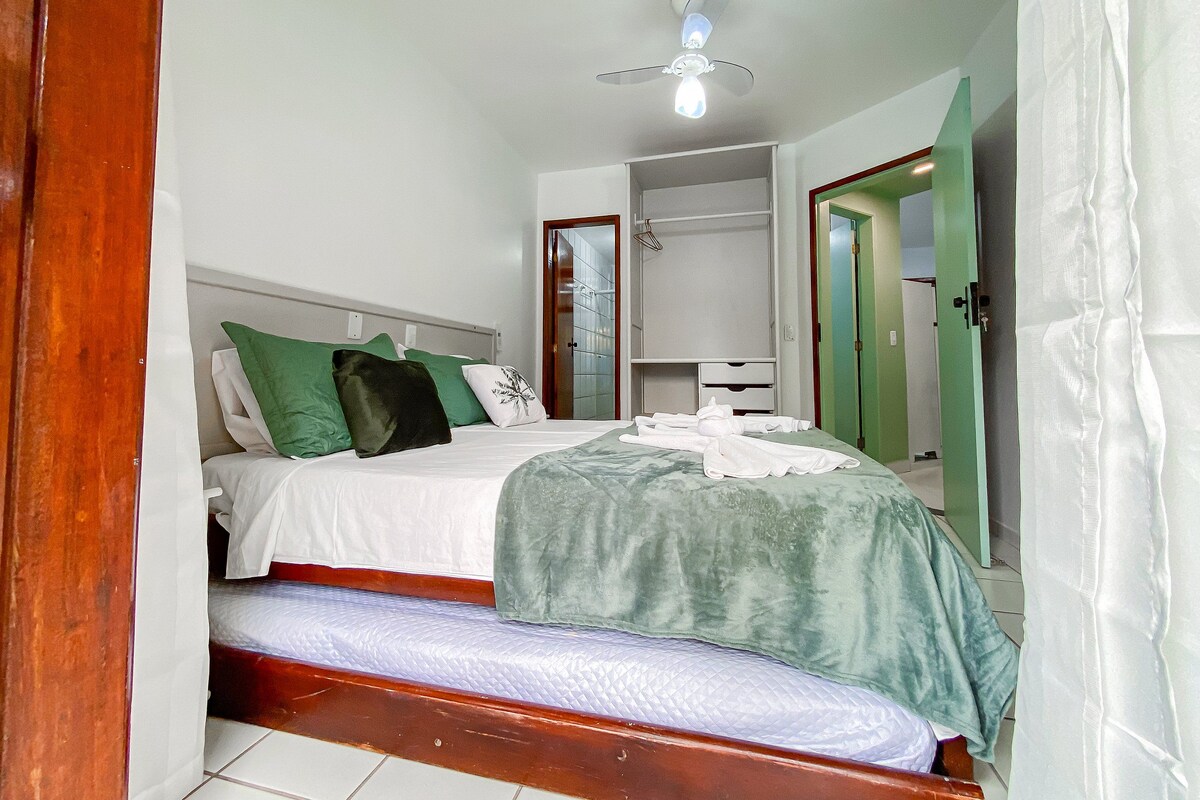 A bedroom with a bed, a wardrobe, and a ceiling fan.