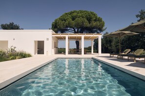 Piscine extérieure en saison, parasols, chaises longues
