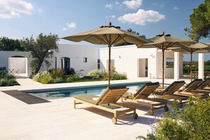 Piscine extérieure en saison, parasols, chaises longues