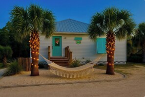 A house with a hammock between two palm trees, a front door, and a small porch. - 7001 Rookery 3 Pools pet Friendly Gulf Shores (Gulf Shores)