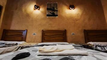 A bedroom with a bed, two wall-mounted lights, and a poster on the wall.