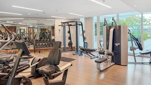 Ett modernt gym med en mängd olika träningsredskap, stora fönster och en ren och rymlig inredning.