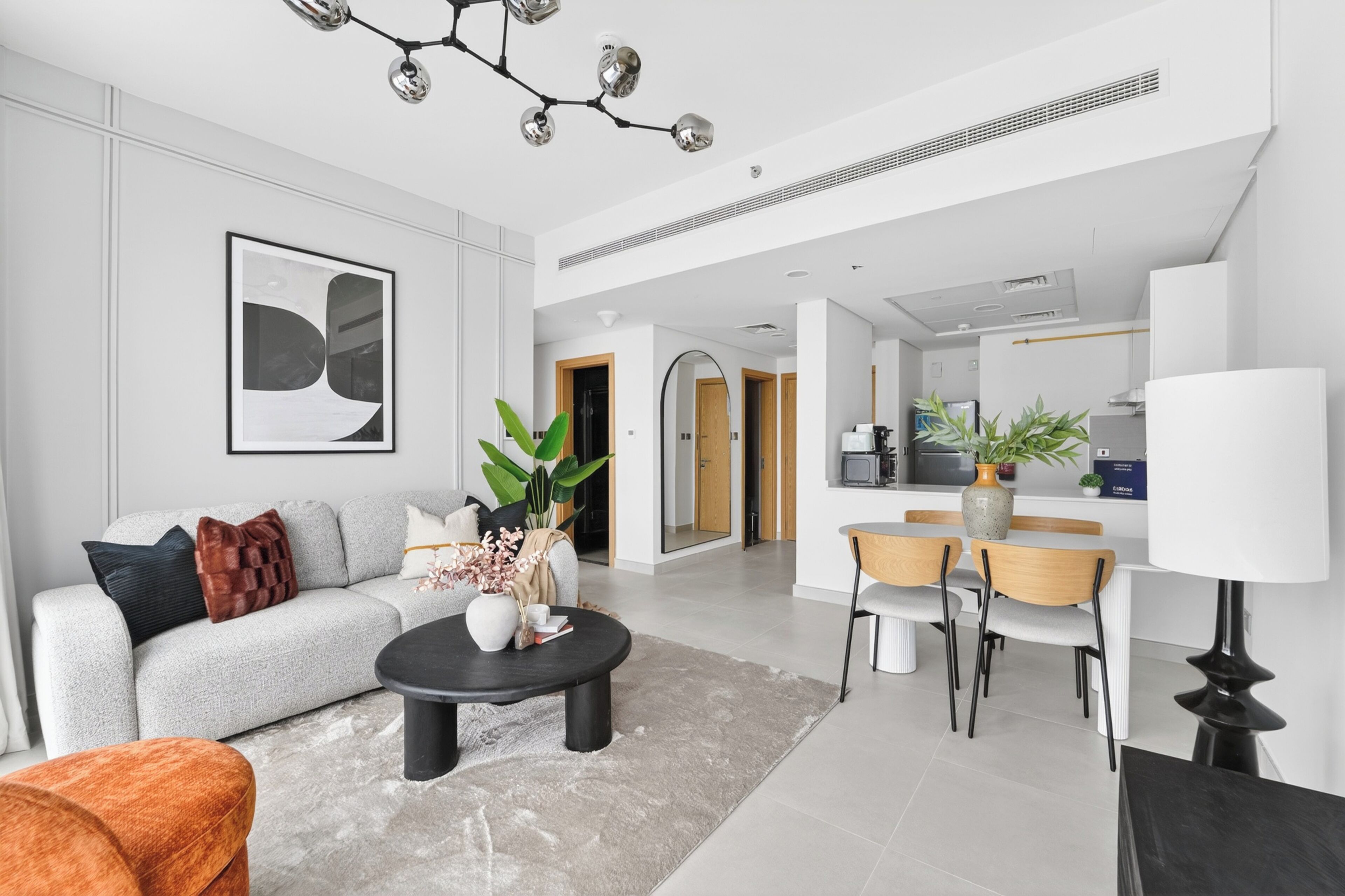 A modern living room with a sofa, coffee table, and dining area.