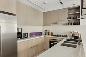 Een moderne keuken met inbouwapparatuur, een roestvrijstalen spoelbak en een houten aanrecht.