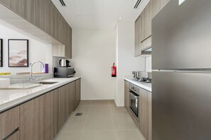 Una cocina moderna con electrodomésticos de acero inoxidable, horno empotrado y microondas.