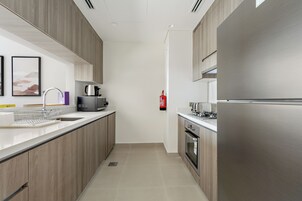 Una cocina moderna con electrodomésticos de acero inoxidable, horno empotrado y microondas.