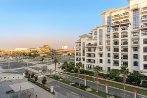 A multi-story hotel with balconies, a parking area, and a road with traffic lights. - Silkhaus Al Battros (Abu Dhabi)