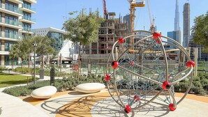 A modern playground with a spherical climbing structure, surrounded by landscaped areas and buildings in the background. - Silkhaus Myrtle 1 (Dubai)