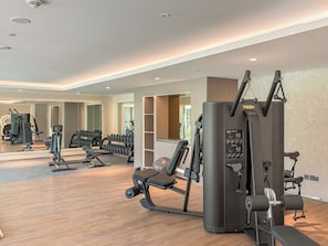 A gym with various exercise equipment, including a cable machine and weight benches. - Silkhaus Myrtle 1 (Dubai)