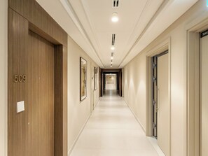 A hotel corridor with a wooden door labeled '509', framed artwork on the walls, and a sign indicating 'Staircase'. - Silkhaus Palace Residences (Dubai)