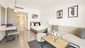 A modern hotel room with a bed, a sofa, a coffee table, and a desk. - Silkhaus Leonardo Residences (Abu Dhabi)