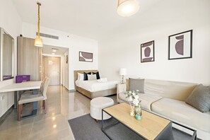 Une chambre d’hôtel moderne équipée d’un lit, d’un canapé, d’une table basse et d’un bureau.
