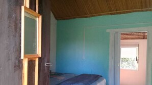 Ein Zimmer mit einem Bett, einer Tür und einem Fenster.