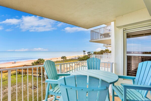 A balcony with a view of the beach, featuring a table and chairs. - Seawinds 204 - Sea Wind Enjoyment (Ormond Beach)