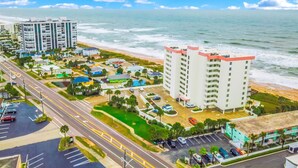 A coastal hotel with multiple floors, a parking lot, and a view of the beach and ocean. - Seawinds 204 - Sea Wind Enjoyment (Ormond Beach)