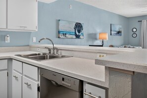 A modern kitchen with a Bosch dishwasher, a double sink, and a countertop. - Ormondy A6 - Ocean Shores Getaway (Ormond Beach)