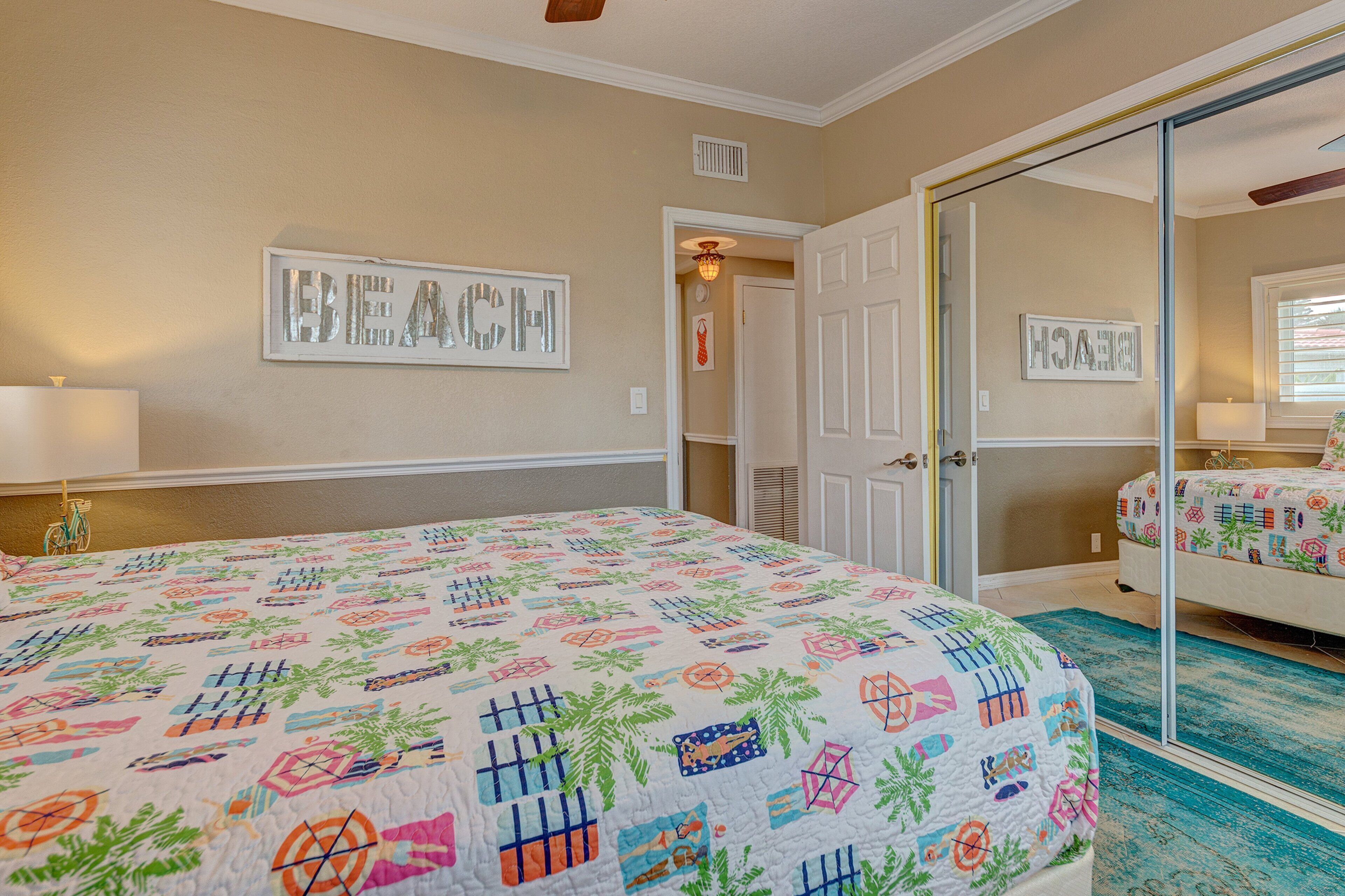 Un dormitorio con cama, espejo y puerta que da a otra habitación.