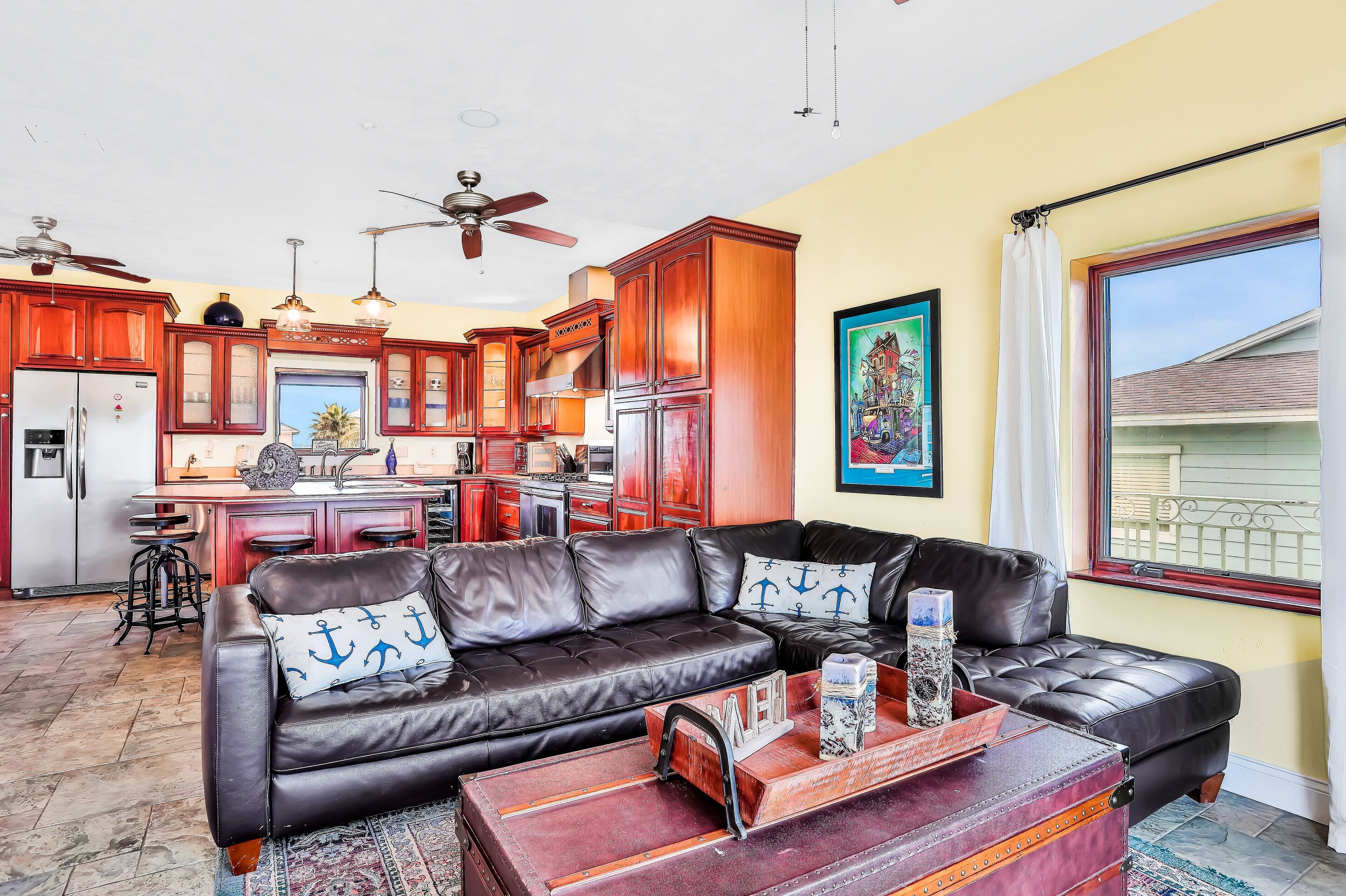 A living room with a leather sofa, a coffee table, and a kitchen in the background.