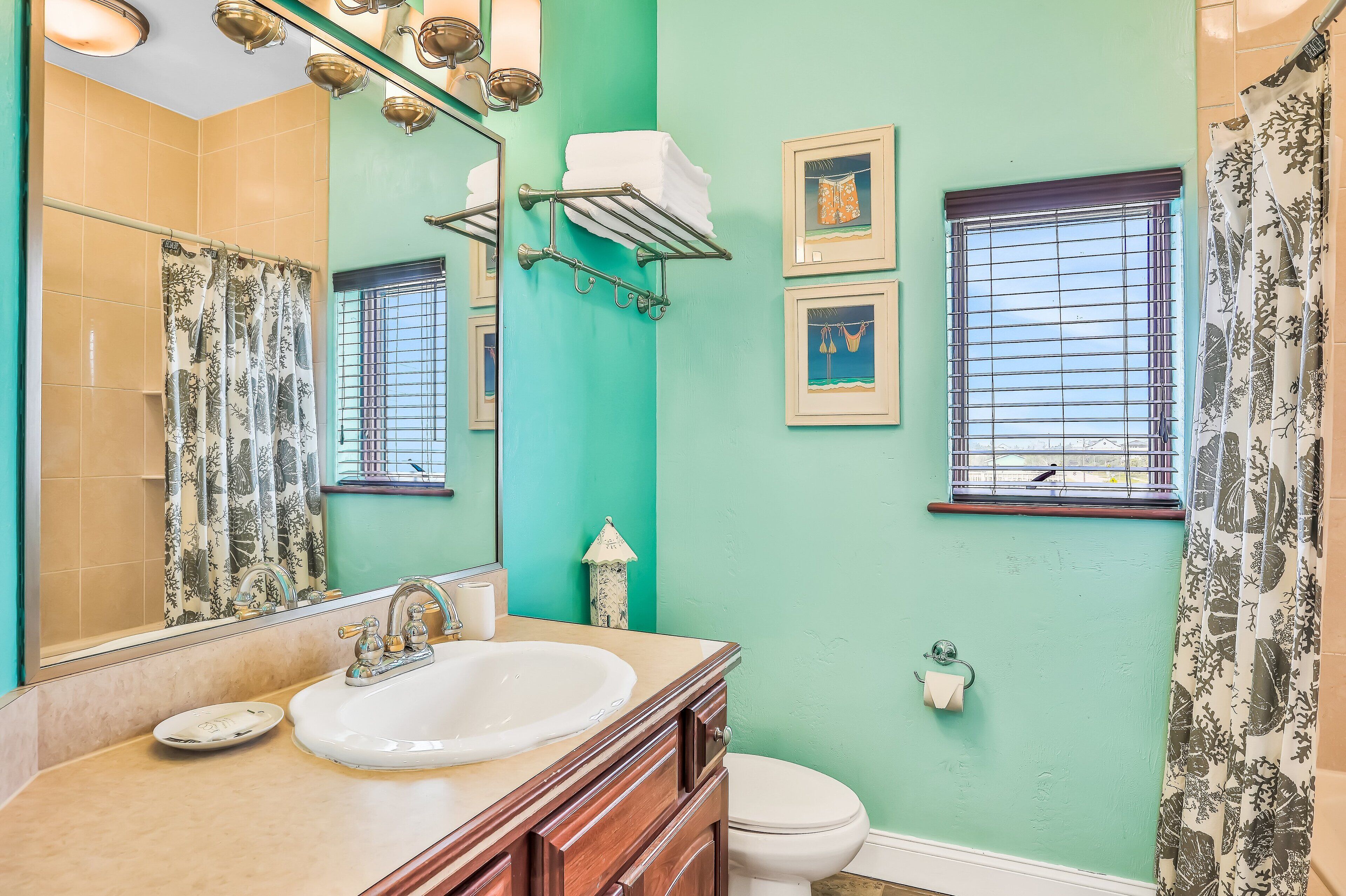 A bathroom with a sink, mirror, and a towel rack.