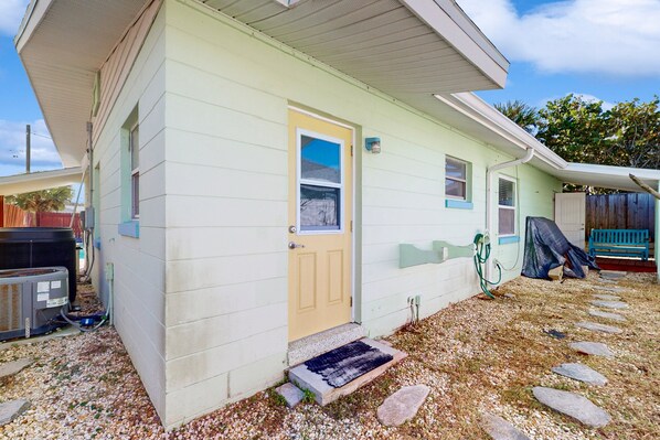 A single-story house with a front door, a small porch, and a covered outdoor area. - Nsb- Seaside Oasis (New Smyrna Beach)