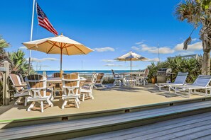 Eine Terrasse mit Sitzgelegenheit, einschließlich Stühle und Tische, sowie eine Fahnenstange mit der US-amerikanischen Flagge.