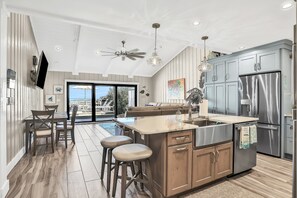 Una cocina moderna con una isla grande, electrodomésticos de acero inoxidable y un ventilador de techo.