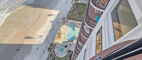 Un hotel de gran altura con zona de piscina, acceso a la playa y vistas al océano.