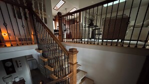 A wooden staircase with a black railing leading to a second floor. - Quiet 3BR Home Near Hospital, Finished Basement, Fast WiFi (Elgin)
