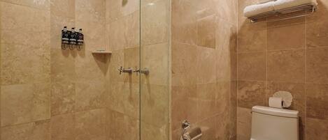 A bathroom with a glass-enclosed shower, a toilet, and a towel rack.