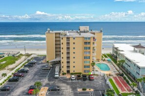 A multi-story hotel with a swimming pool, parking lot, and ocean view. - NSB Ponce de Leon Towers 507 (New Smyrna Beach)