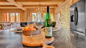 Een houten interieur met een keukentafel, een fles Riesling en een schaal fruit.