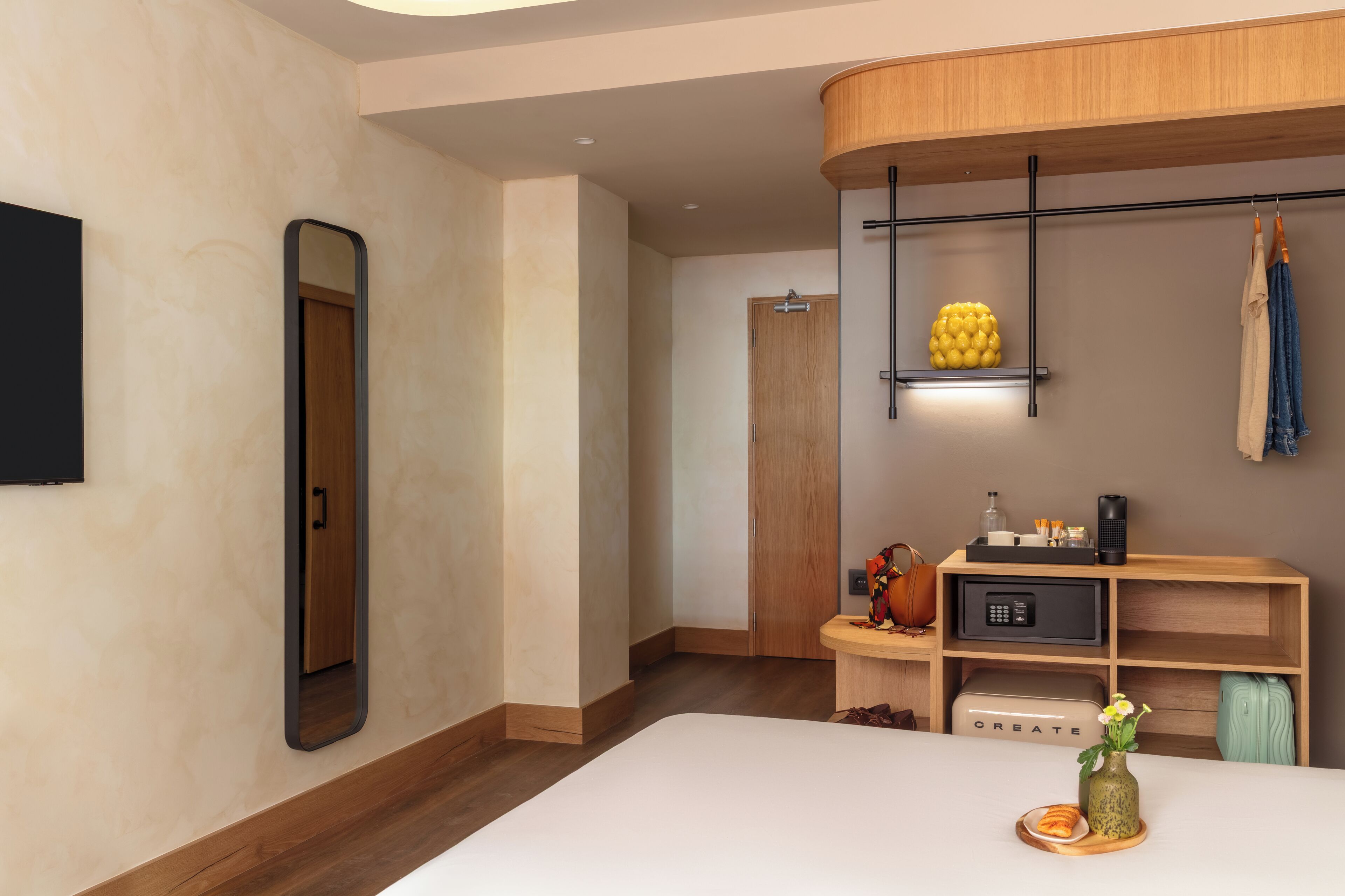 Un baño moderno con un espejo grande, tocador de madera y zona de ducha.