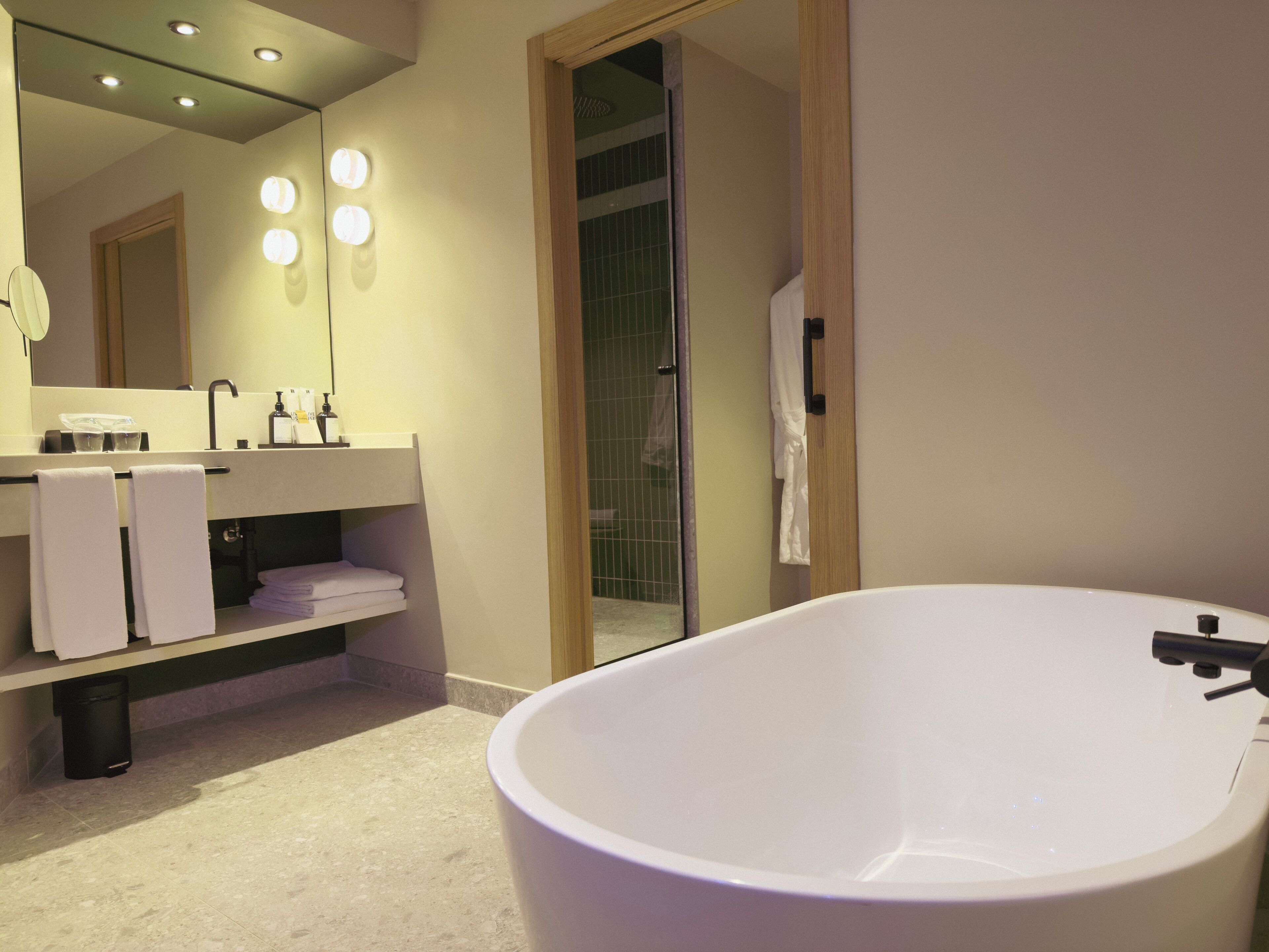 Une salle de bain moderne avec une grande baignoire, un meuble-lavabo avec un miroir et un espace douche.