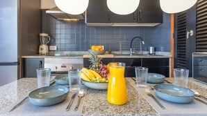A modern kitchen with granite countertops, a fruit bowl, and a juice pitcher. - Arizona's Bay Holiday Home with Sea Views, Hot Tub, and Private Terrace (Mogán)