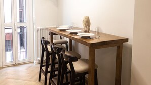 A dining area with a wooden table, four chairs, and a vase. - Morazzone suite - Chinatown (Milano)