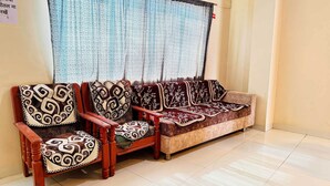A seating area with a sofa and two armchairs, each with patterned cushions. - Hotel Star 21 (Indore)