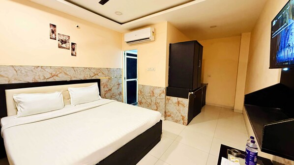 Une chambre d’hôtel équipée d’un lit, d’une télévision, d’une armoire et d’un appareil de climatisation.