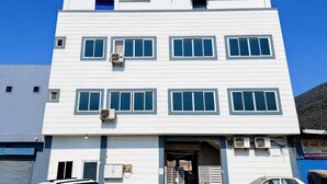 A multi-story building with a flat facade, multiple windows, and air conditioning units. - Hotel Star 21 (Indore)