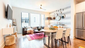 A modern kitchen with a built-in refrigerator, a dining area with a round table and striped chairs, and a large window with blinds. - 8 Minutes To Downtown Nashville Wifi And Workspace (Nashville)