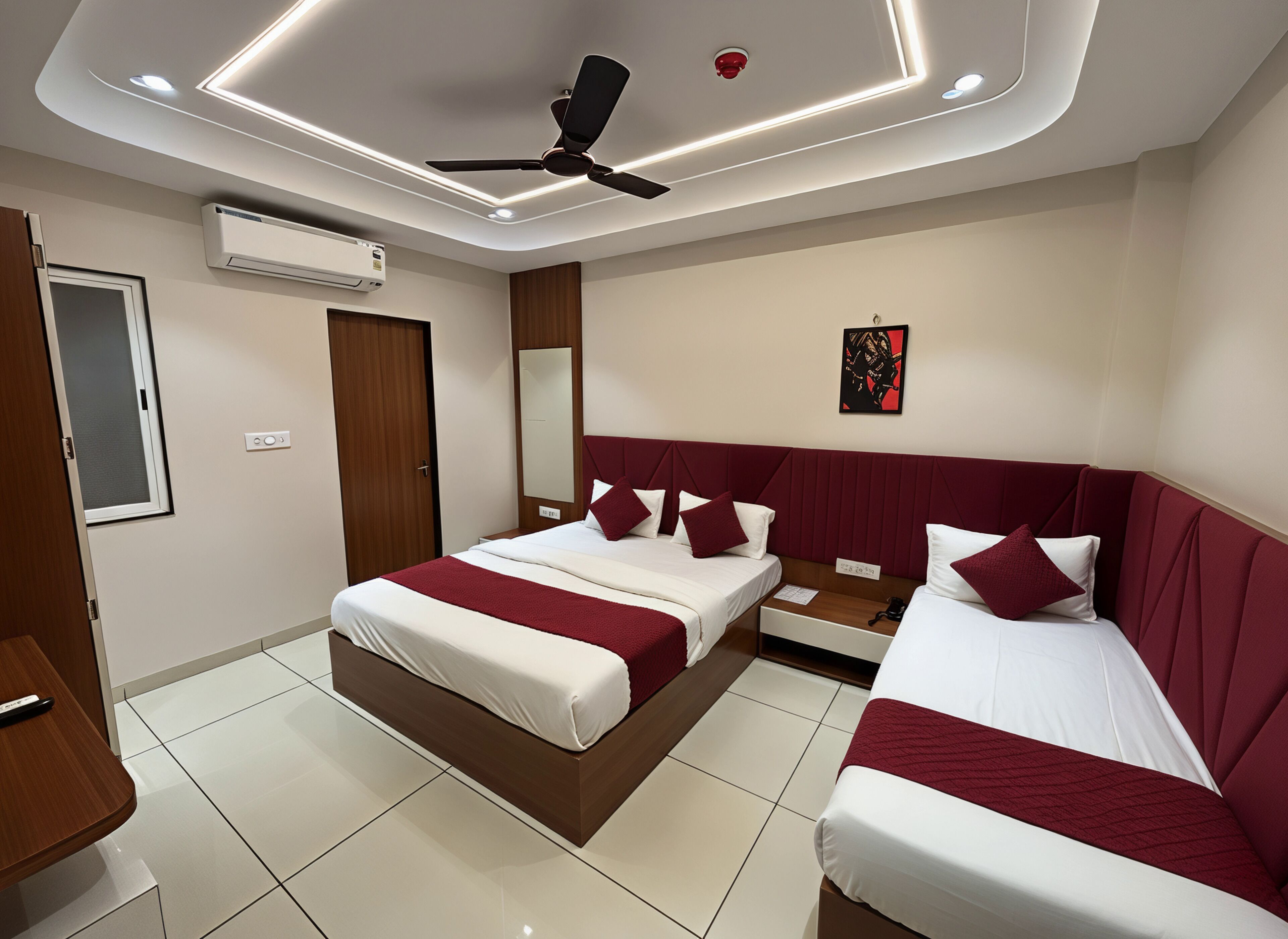 A modern hotel room with a large bed, a smaller bed, a desk, and a ceiling fan.