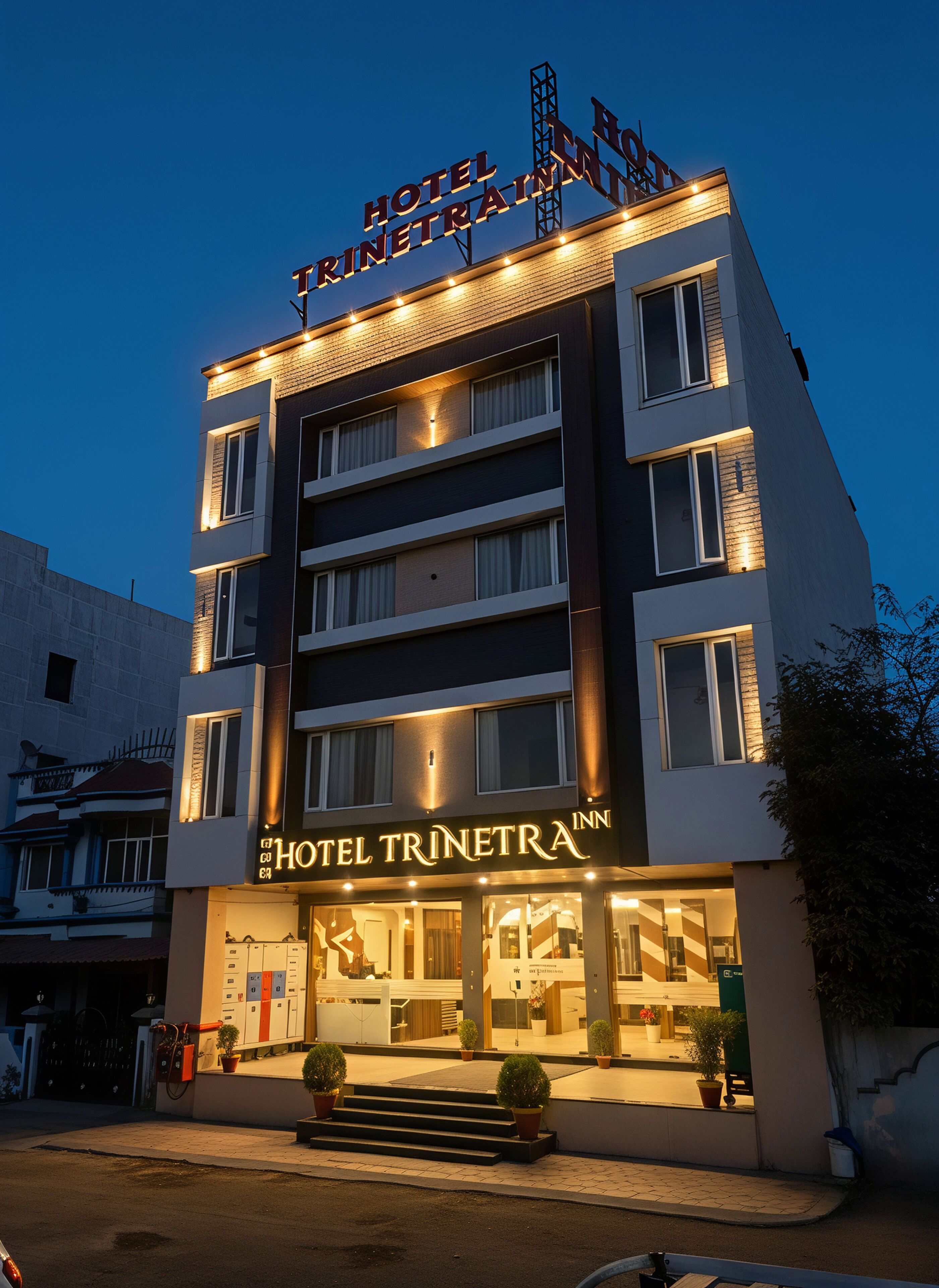 Un hôtel à plusieurs étages, reconnaissable à son enseigne bien visible où l’on peut lire « HÔTEL TRINETRA ».