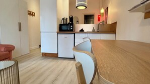 A compact kitchen with a refrigerator, microwave, and sink. - CASA BLUM #2 - Studio climatisé, à 2 pas de la gare (Brive-la-Gaillarde)