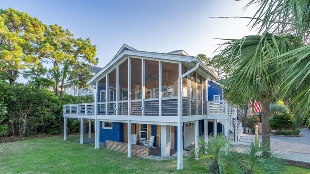 A two-story house with a covered porch and a fenced backyard. - Beach Access, Hot Tub, Ping Pong Table, Bikes! (Tybee Island)