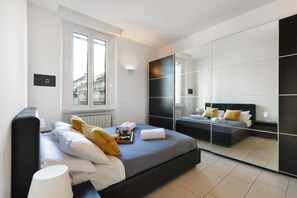 Une chambre moderne avec un grand lit, une table de chevet, un miroir et une fenêtre.