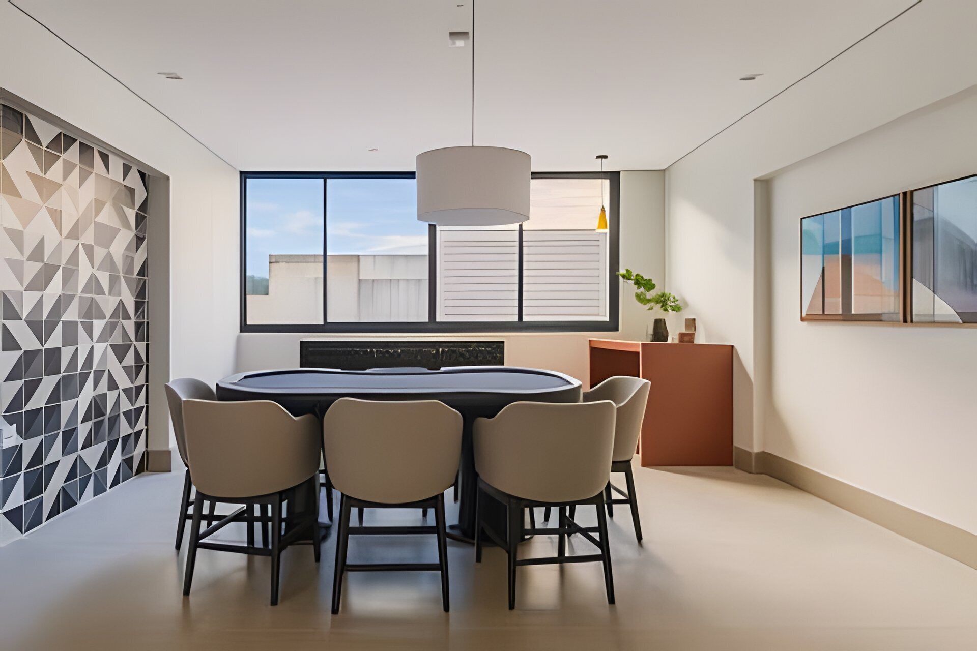 A modern dining area with a round table, four chairs, a pendant light, a large window, and a geometric wall pattern.