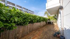 A wooden deck with a bamboo fence and potted plants. - L'Écrin Toulousain - Piscine partagée et parking (Toulouse)