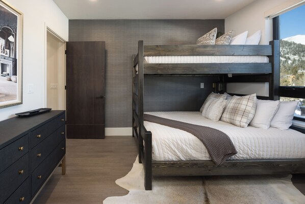 A bunk bed with a view of a snowy landscape, a dark dresser with gold handles, and a white rug. - 214 - NEW BUILD - Downtown Frisco - Private Hot Tub w/Mountain View! (Frisco)