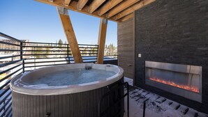 A wooden deck with a hot tub and a stone fireplace. - 214 - NEW BUILD - Downtown Frisco - Private Hot Tub w/Mountain View! (Frisco)