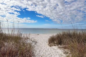 A sandy beach path leading to the ocean with sparse vegetation on either side. - Salty Joe's-WindMark Beach-Pools-Golf Cart-Sleeps 10-InLaw Suite (Port St. Joe)