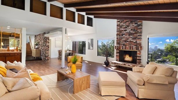 A spacious living room with a fireplace, wooden flooring, and a view of the outdoors. - Elegant City View | Quick Drive to LA | Hot Tub (La Crescenta-Montrose)